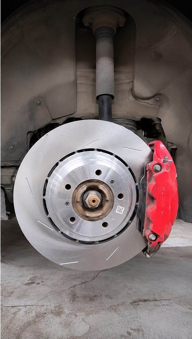 Disque de frein neuf et étrier rouge montés sur le véhicule, atelier Fensch Car Service à Nilvange